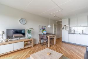 a kitchen and living room with a table and a tv at Appartementencomplex Juliana 146 in De Koog