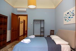 ein Schlafzimmer mit einem blauen Bett mit zwei Handtüchern darauf in der Unterkunft VESPRI 15 apartments in Trapani