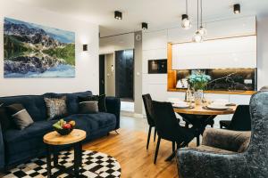 un salon avec un canapé et une table dans l'établissement Apartamenty Bujaś Resort Białka Blue Ski - obok Termy Bania, à Białka Tatrzańska