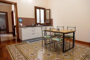 Una cocina con una mesa y sillas y un fregadero. en VESPRI 15 apartments, en Trapani