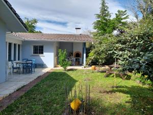 une maison avec une cour avec une table et des chaises dans l'établissement SABLE BLEU, maison d'architecte, à Andernos-les-Bains