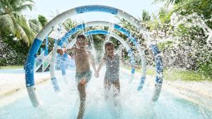 Trzech młodych chłopców bawiących się w parku wodnym w obiekcie Intercontinental Maldives Maamunagau Resort with Club benefits by IHG w mieście Raa Atoll