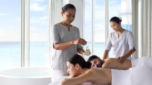 kobieta dająca mężczyźnie masaż w łóżku w obiekcie Intercontinental Maldives Maamunagau Resort with Club benefits by IHG w mieście Raa Atoll +276 zdjęć