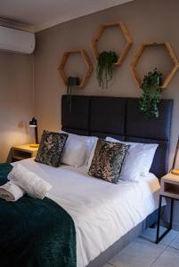 a bedroom with a large bed with plants on the wall at Wisteria Cottages in Bloemfontein