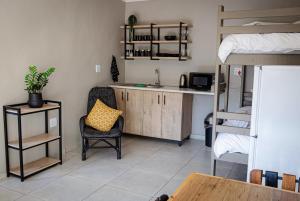 a room with a kitchen and a bunk bed at Wisteria Cottages in Bloemfontein
