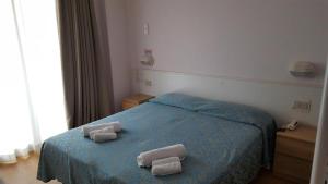 a bedroom with a blue bed with two towels on it at Little Hotel in Riccione