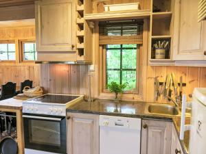 a kitchen with wooden cabinets and a stove top oven at Holiday Home Skafjellstoga by Interhome in Åmli