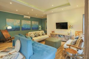 KomodoVilla Komoko的客厅里有一张蓝色沙发和一台电视