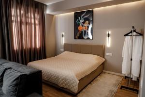 a bedroom with a bed and a painting on the wall at Апартаменты в ЖК Green Plaza с джакузи in Aktau +42 photos