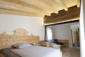 1 dormitorio con 1 cama y pared de madera en Kleines Zirbelhotel - ÜF en Oberammergau