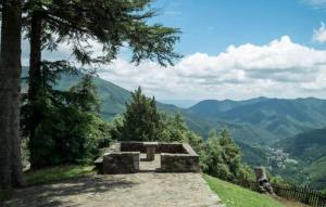a stone bench on a hill with a view of mountains at Rectoria Santuari del Coll in Girona