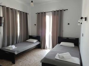 two beds sitting in a room with a window at Διαμέρισμα 1 ΣΤΗΝ ΑΓΙΑ ΜΑΡΙΝΑ in Agia Marina Aegina