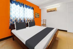 duże łóżko w pokoju z pomarańczowymi ścianami w obiekcie OYO Gala Vista w mieście Selam