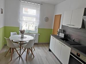 a kitchen with a table and chairs in a kitchen at Ferienwohnung Hosang in Thale