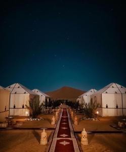 梅爾祖卡的住宿－Opulent Sahara Camp，夜色沙漠中的一排白 ⁇ 