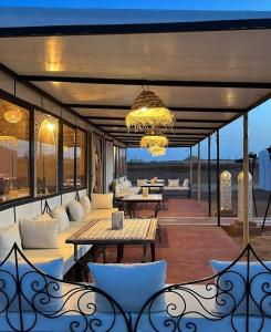 梅爾祖卡的住宿－Opulent Sahara Camp，配有白色家具和吊灯的庭院