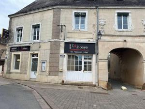 a brick building with an entrance to a garage at Bistrot de L'abbaye in Tuffé