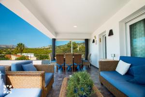 een woonkamer met blauwe banken en een balkon bij Villa Bernia by Abahana Villas in Benissa