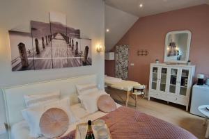 ein Schlafzimmer mit einem Bett und einem Gemälde an der Wand in der Unterkunft Le Cocon chambre avec Jacuzzi privatif Normandie in Couvains