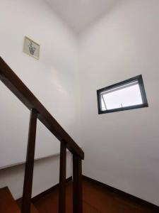 a staircase with a window in a white wall at 辉煌夜市 4房泳池花园别墅 订4日提供免费接机 in Ban Na Song