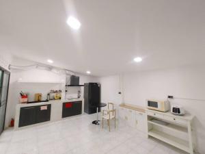 a large white kitchen with a counter and a table at 辉煌夜市 4房泳池花园别墅 订4日提供免费接机 in Ban Na Song