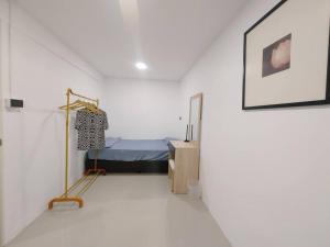 a room with a bed in a white room at 辉煌夜市 4房泳池花园别墅 订4日提供免费接机 in Ban Na Song