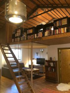 a living room with a book shelf and a spiral staircase at ANTALYA KALEİÇİ ÖZEL MÜSTAKİL BAHÇELİ VİLLa in Antalya