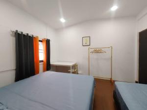 a bedroom with two beds and a desk in it at 辉煌夜市 4房泳池花园别墅 订4日提供免费接机 in Ban Na Song