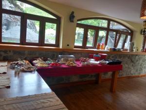 a table with food on it in a room with windows at Hostel in Valbonë +5 photos