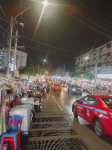 a group of cars driving down a city street at night at 辉煌夜市 4房泳池花园别墅 订4日提供免费接机 in Ban Na Song