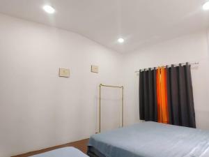 a white room with a bed and a curtain at 辉煌夜市 4房泳池花园别墅 订4日提供免费接机 in Ban Na Song