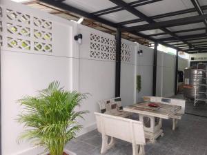 a patio with a table and chairs and plants at 辉煌夜市 4房泳池花园别墅 订4日提供免费接机 in Ban Na Song