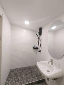 a white bathroom with a sink and a mirror at 辉煌夜市 4房泳池花园别墅 订4日提供免费接机 in Ban Na Song