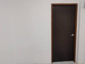a brown door in a room with a white wall at 辉煌夜市 4房泳池花园别墅 订4日提供免费接机 in Ban Na Song
