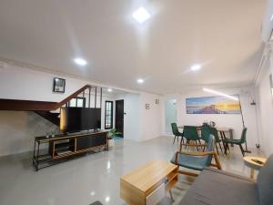 a living room with a couch and a dining room at 辉煌夜市 4房泳池花园别墅 订4日提供免费接机 in Ban Na Song