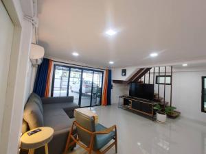 a living room with a couch and a tv at 辉煌夜市 4房泳池花园别墅 订4日提供免费接机 in Ban Na Song