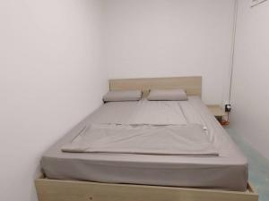 a bed with two pillows on top of a box at 辉煌夜市 4房泳池花园别墅 订4日提供免费接机 in Ban Na Song