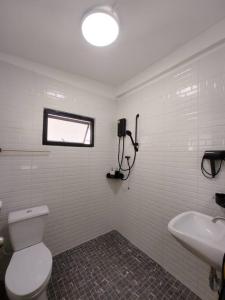 a bathroom with a toilet and a sink and a window at 辉煌夜市 4房泳池花园别墅 订4日提供免费接机 in Ban Na Song