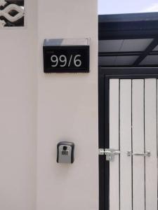a door with a sign on the side of a building at 辉煌夜市 4房泳池花园别墅 订4日提供免费接机 in Ban Na Song