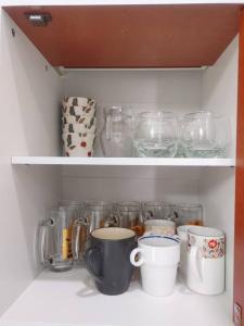 a shelf with cups and other glass items on it at 辉煌夜市 4房泳池花园别墅 订4日提供免费接机 in Ban Na Song