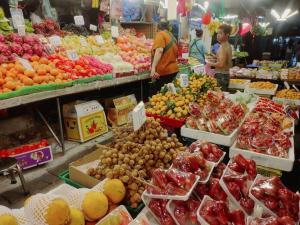 a market filled with lots of fruits and vegetables at 辉煌夜市 4房泳池花园别墅 订4日提供免费接机 in Ban Na Song