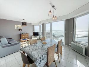 a dining room with a table and a couch at Bel appartement en front de mer avec balcon, parking et équipements modernes - FR-1-361-327 in Granville