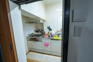 a small kitchen with a sink and a stove at 一宿一景一生縁-千葉県四街道店 in Yotsukaidō