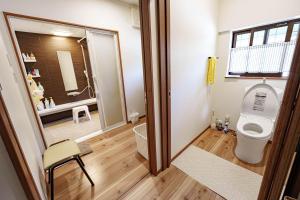 a bathroom with a toilet and a mirror at 一宿一景一生縁-千葉県四街道店 in Yotsukaidō