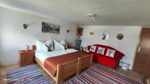 una camera da letto con un letto grande con un copriletto rosso di Ferienhaus Strassgartl a Pinsdorf Altre 37 foto