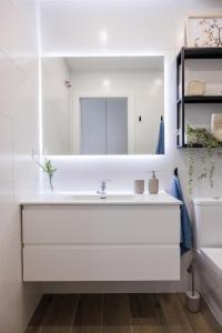 a white bathroom with a sink and a mirror at Ranhomes rentals apartments in Nueva Andalucia