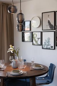 a dining room with a wooden table and pictures on the wall at Ranhomes rentals apartments in Nueva Andalucia