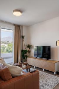 a living room with a couch and a flat screen tv at Ranhomes rentals apartments in Nueva Andalucia +42 photos