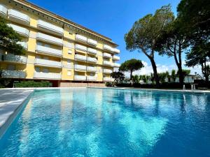 a swimming pool in front of a building at Cozy flat with shared pool in Porto Santa Margherita di Caorle