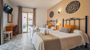 a hotel room with two beds and a television at AzuLine Hostal Dinamarca in San Antonio +71 photos